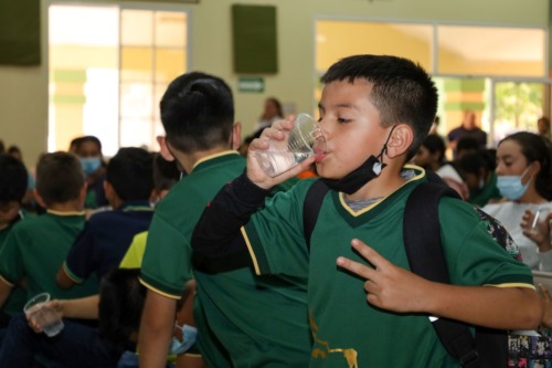 A student at Academia La Providencia drinks water.